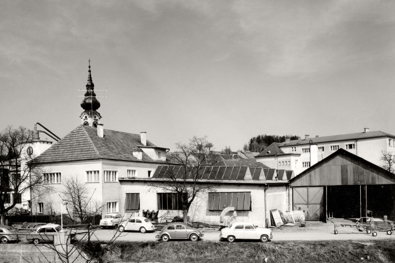 Vista parziale del centro di Grieskirchen: lo stabilimento di produzione I di PÖTTINGER verso il 1960. Pare che il maggiolino VW fosse molto amato dai dipendenti PÖTTINGER.