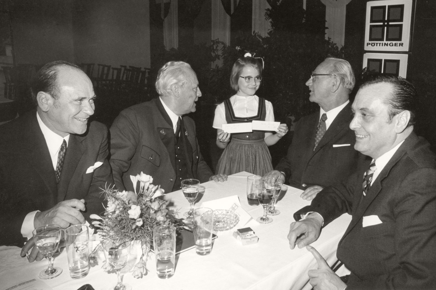 L'attenzione del cancelliere Franz Jonas (secondo da destra) è completamente rivolta alla signorina accanto al tavolo.